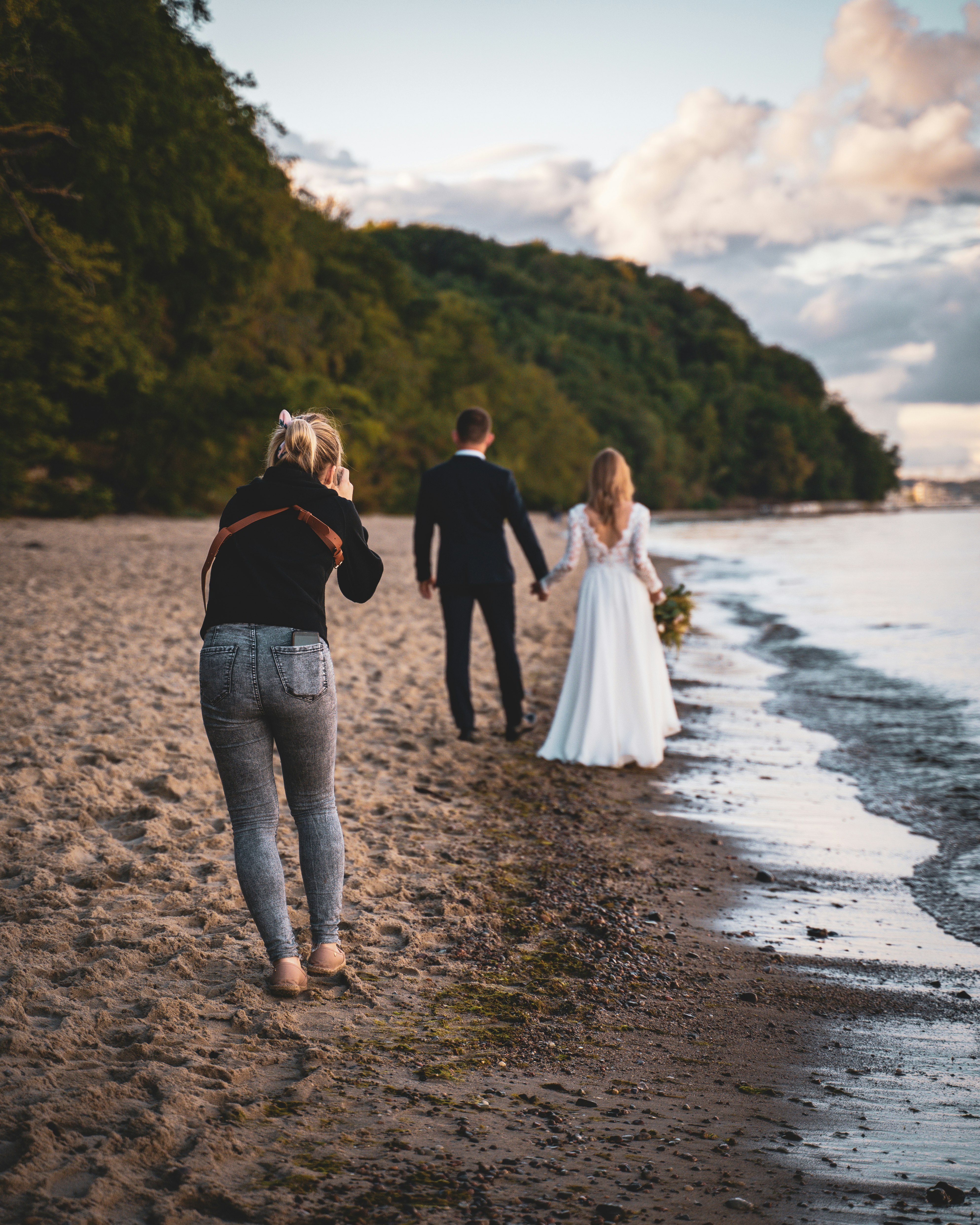 man and woman walking on beach during daytime